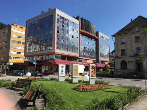 a building with a park in the middle of a city at Hôtel des Trois Rois in Le Locle
