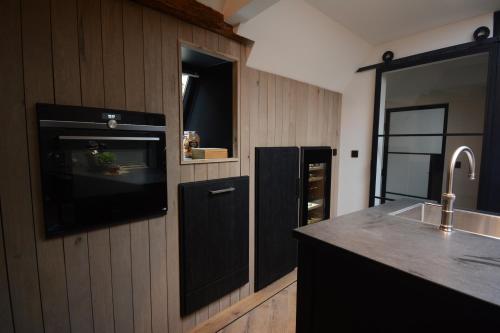 uma cozinha com um lavatório e uma bancada em Goudgenog em Appingedam