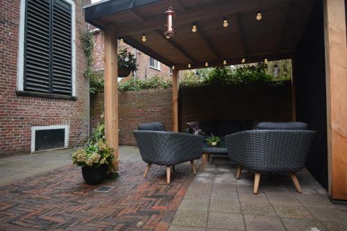 a pergola with chairs and a table on a patio at Goudgenog in Appingedam