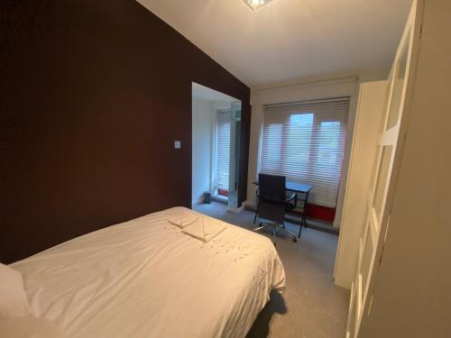 um quarto com uma cama e uma secretária com uma cadeira em Lovely bright double room very central em Londres