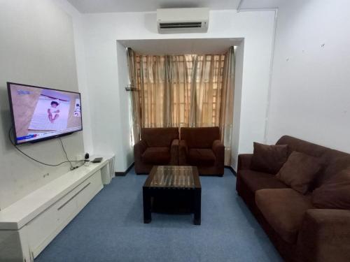 uma sala de estar com um sofá e uma televisão em NUR MUHAMMAD HOMESTAY em Kubang Kerian