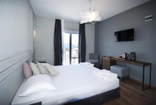 a bedroom with a large white bed and a desk at Bodrum Smart City Hotel in Bodrum City