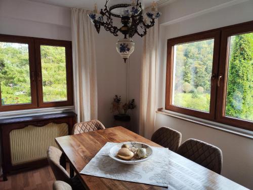 - une salle à manger avec une table et deux fenêtres dans l'établissement Wohlfühloase Eifelsteig, à Simmerath