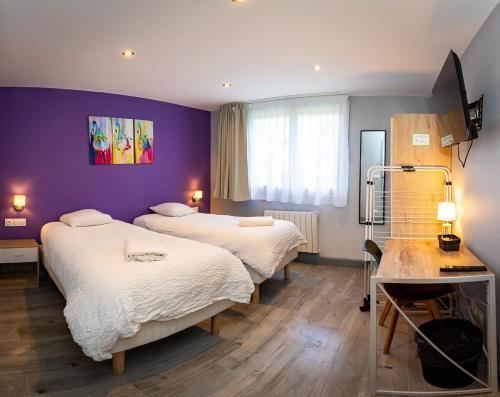 um quarto com 2 camas e uma parede roxa em Résidence Hermès Paris Orly Aéroport em Villeneuve-le-Roi