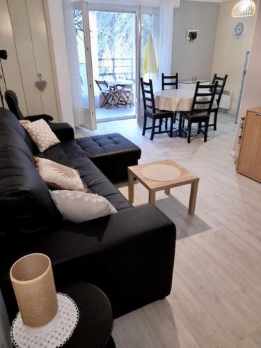 un salon avec un canapé noir et une table dans l'établissement Appartement location thermale, à Amélie-les-Bains-Palalda