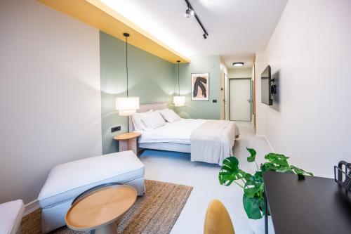 een slaapkamer met een bed, een tafel en een bank bij Superb Petrova Street Rooms in Zagreb