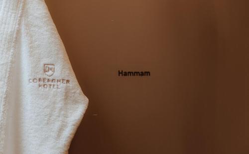 a towel with the name of a hotel on it at Cobergher Hotel in Kortrijk