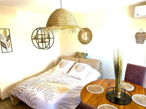 a bedroom with a bed and a wooden table at L'Evasion - Climatisé - Jardin - Plage - Jacuzzi in Perpignan