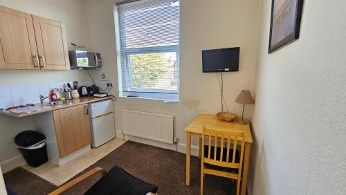a small kitchen with a small table and a small table and a kitchen at ABBEY HOTEL in Stafford