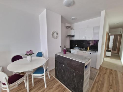 a kitchen with a table and a white table and chairs at Flat Rafailovic One minute to Beach in Budva