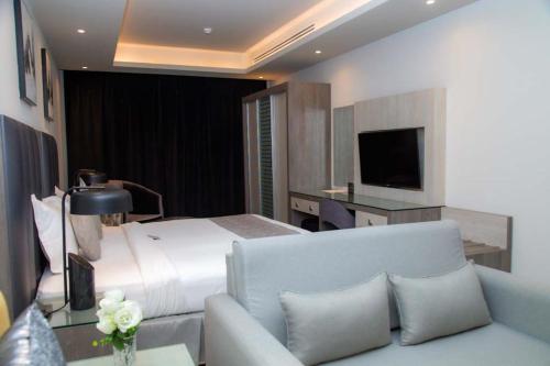 a bedroom with a bed and a couch and a television at Seven Palaces in Hafr Al-Batin