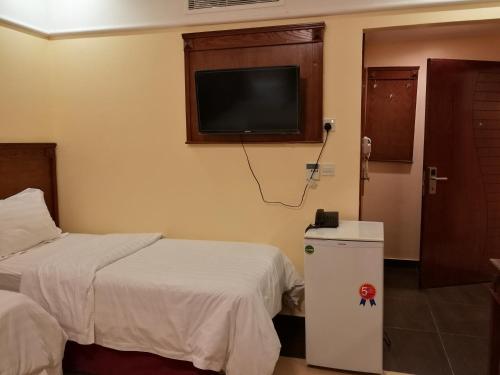 a hotel room with two beds and a flat screen tv at جوار البيت مكة in Makkah