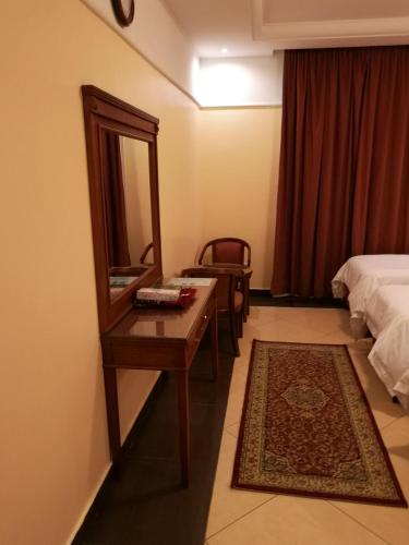 a hotel room with a dressing table and a mirror at jiwar al bait makkah جوار البيت in Makkah