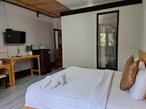 a bedroom with a white bed with towels on it at Mookboonchu Guesthouse ,Kohmook Trang in Koh Mook
