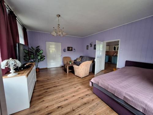 - une chambre avec un lit et un salon dans l'établissement Domek przy Maja, à Milicz