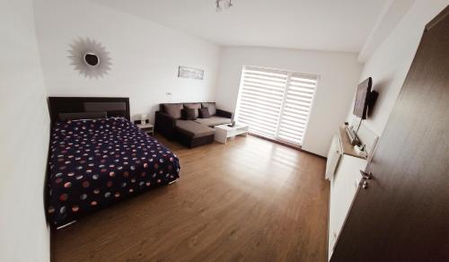 een slaapkamer met een bed en een bank in een kamer bij Vivamus Studio in Braşov