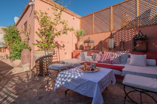 a patio with a couch and tables on a patio at Riad médina Authentique Marrakech in Marrakesh