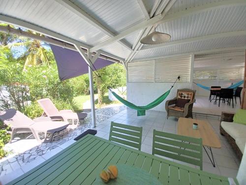 a living room with a hammock on a patio at La Rose du Bresil Marie-Galante in Capesterre-de-Marie-Galante