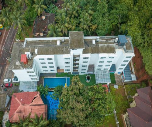 an overhead view of a building with a pool and trees at HUE GUH The Porto Candolim in Calangute