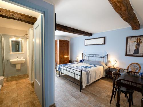 Schlafzimmer mit einem Bett, einem Schreibtisch und einem Waschbecken in der Unterkunft Fermo della Guazzona in Busseto