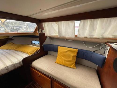 a small room with a bed and a yellow pillow at Barco acogedor - Cosy Boat - Barcelona in Barcelona