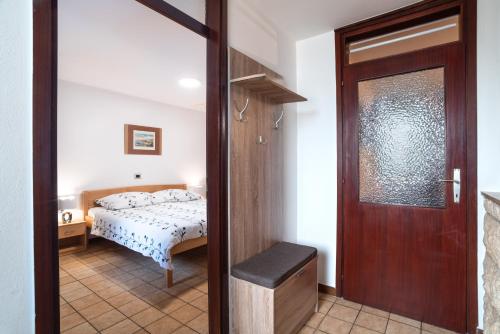 a bedroom with a bed and a door leading into a room at Apartments Vila Toni in Portorož