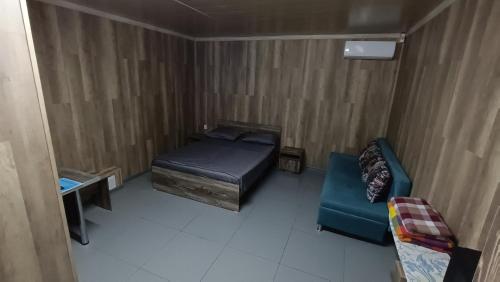 a small bedroom with a bed and a couch at The Mini-hotel on Mukanov St in Almaty