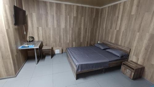 a bedroom with a bed and a table and a television at The Mini-hotel on Mukanova St in Almaty