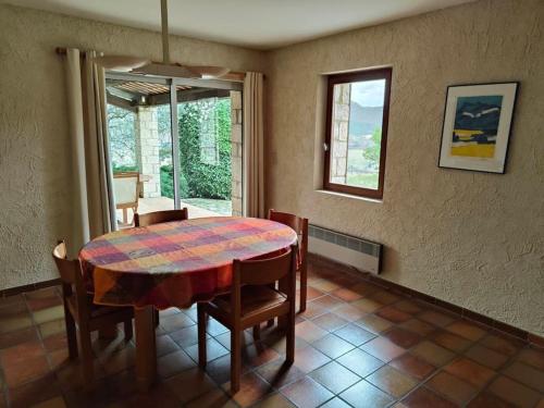 comedor con mesa, sillas y ventana en Maison spacieuse idéale pour vacances en famille, en Montbrun-les-Bains