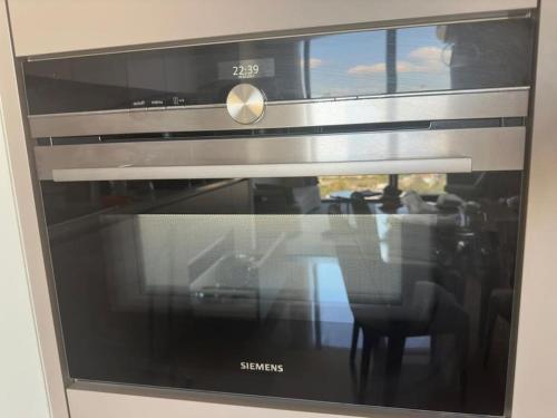 a microwave oven with a reflection of a table at Best opportunity in emaar in Istanbul