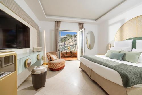 um quarto de hotel com uma cama e uma televisão em Hotel Punta Tragara em Capri