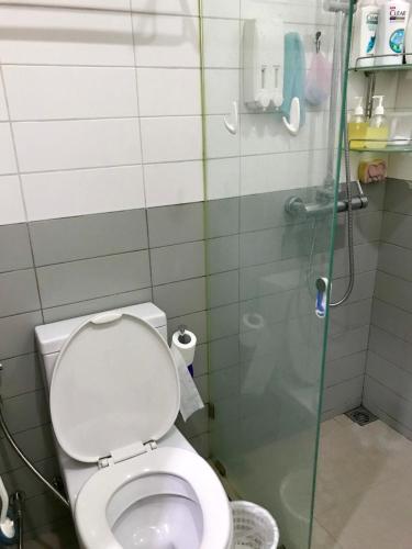 een badkamer met een toilet en een glazen douchecabine bij Sukhumvit 81 in Bangkok