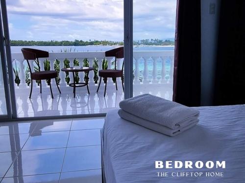 1 dormitorio con cama, sillas y balcón en Clifftop Home with Amazing View, en Esperanza