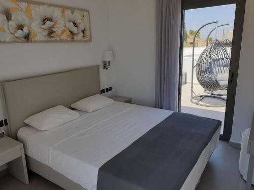 um quarto com uma cama e vista para uma varanda em Nafplio Villa, pool & sea view em Tolo