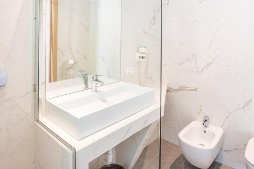 a white bathroom with a sink and a toilet at Centro Vacanze La Limonaia in Limone sul Garda