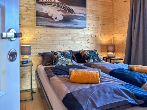 two beds in a room with wooden walls at Holzhaus in Diemelsee