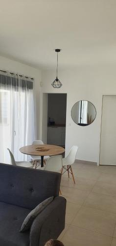 a living room with a couch and a table and chairs at Maison Bord de mer refaite à neuf in Canet-en-Roussillon