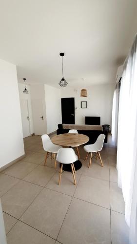 une salle à manger avec une table et deux chaises dans l'établissement Maison Bord de mer refaite à neuf, à Canet