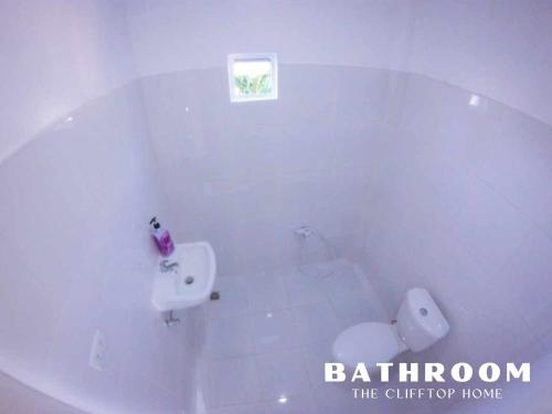 biała łazienka z umywalką i toaletą w obiekcie Clifftop Home with Amazing View w mieście Esperanza