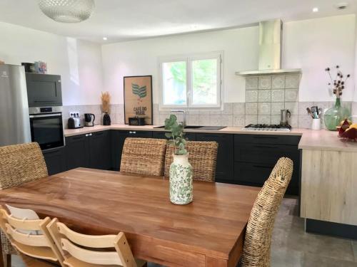 une cuisine avec une table en bois et un vase. dans l'établissement Villa avec piscine proche de Nîmes & Montpellier, à Sardan