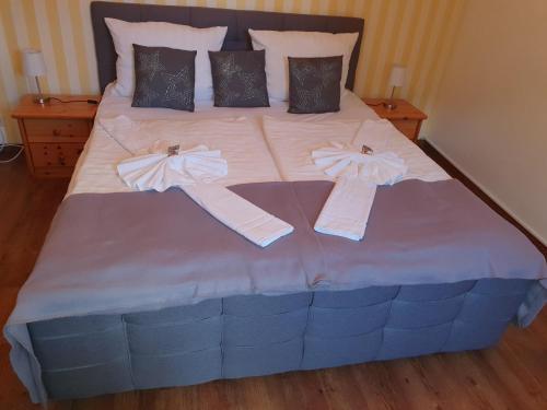 a bed with two towels and bows on it at Altstadtcafé und Pension in Havelberg