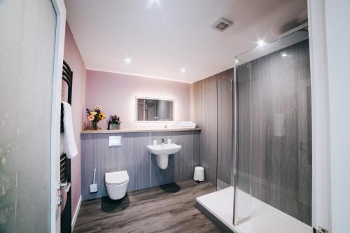a bathroom with a sink and a toilet and a shower at The Cosy Coo Shed in Forfar