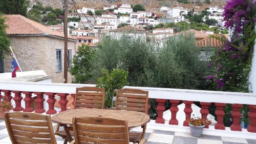 a table and chairs on the balcony of a house at Ippokampos in Hydra