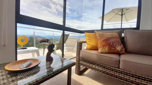 a living room with a couch and a glass table at Casas Campestres Los Miradores de Fruworld in Carmen de Apicalá