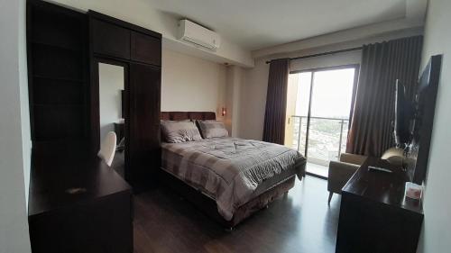 een slaapkamer met een bed en een groot raam bij Ruby Apartment #22 in Kejayan