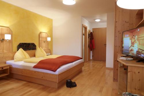 a bedroom with a bed and a flat screen tv at Hotel Malteinerhof in Malta