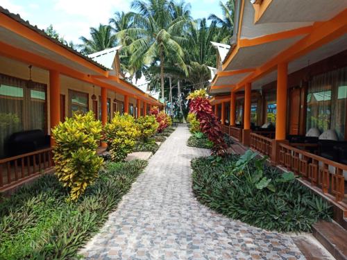 a walkway leading to a building with flowers and plants at Gold India Beach Resort in Havelock Island