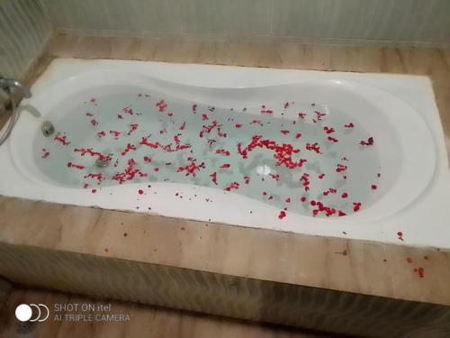 eine weiße Badewanne mit roten Streuseln in der Unterkunft Gold India Beach Resort in Havelock Island