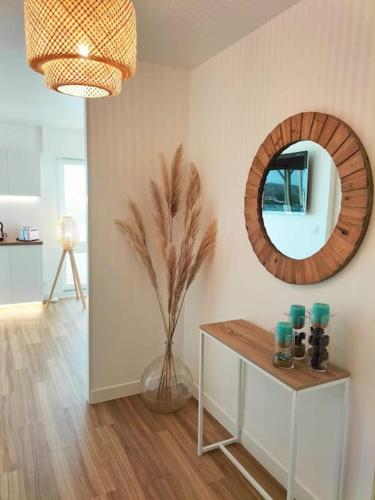 - un salon avec une table et un miroir dans l'établissement Studio face mer pieds dans l’eau, à Saint-Hilaire-de-Riez