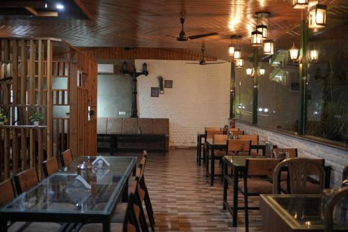 un comedor con mesas y sillas en un restaurante en Panambi Tapovan Resort, en Rishīkesh